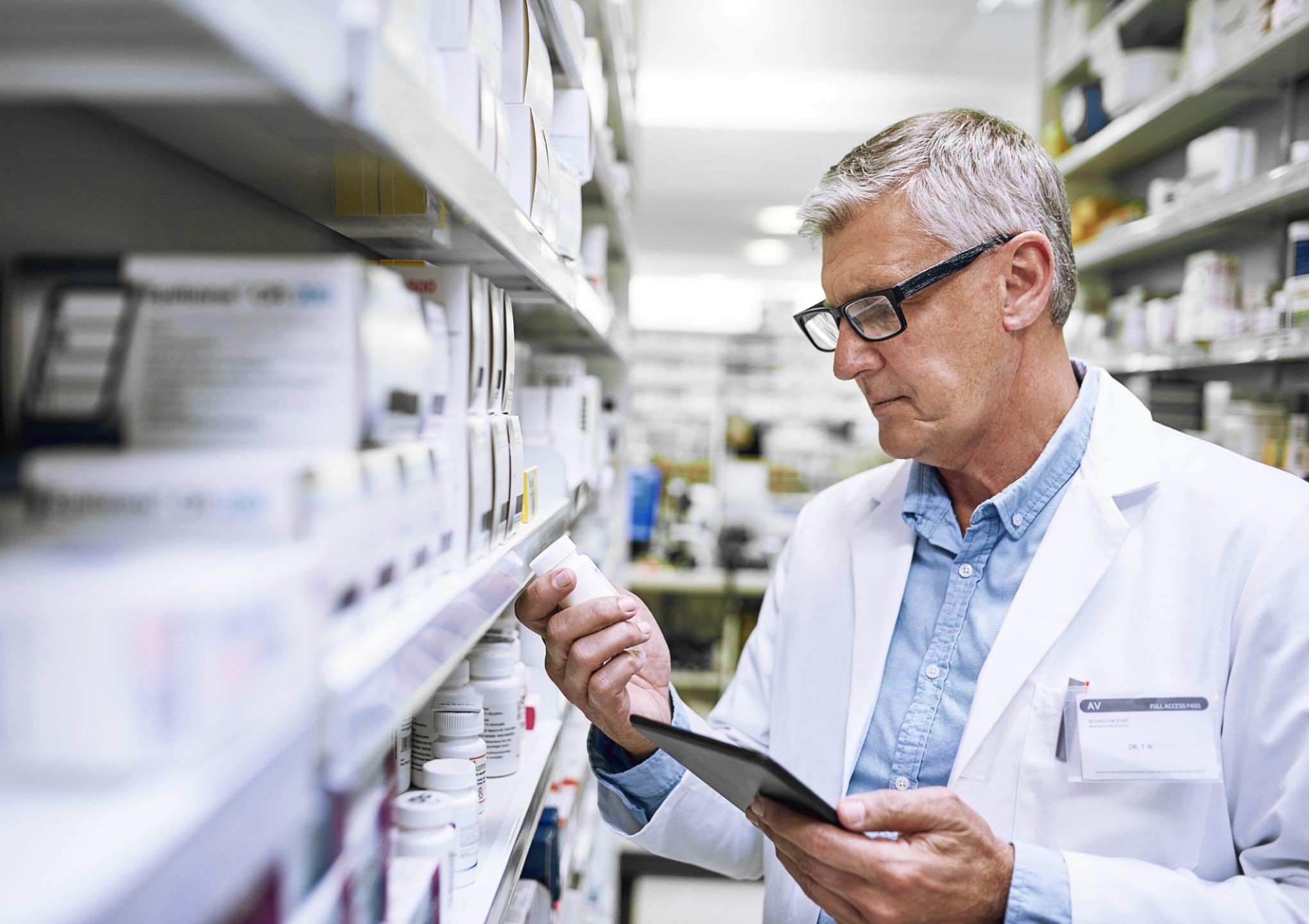 male pharmacists looking at pill bottle