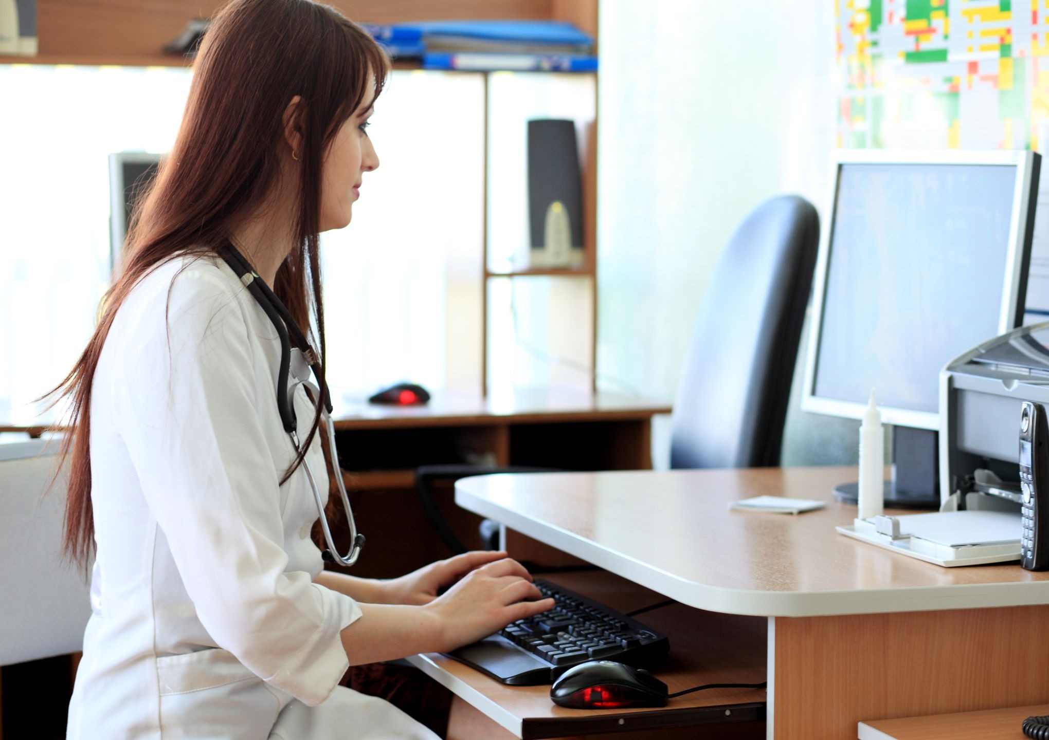 woman sitting at desk reading monitor