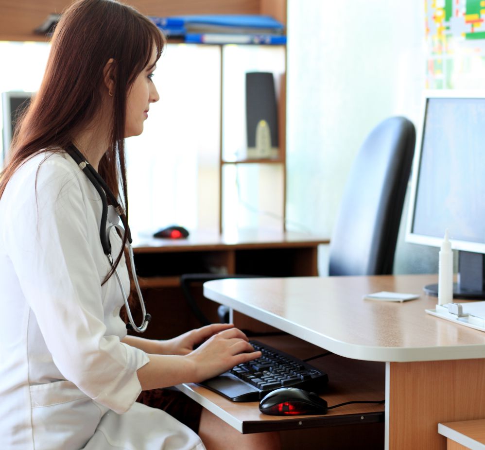 doctor sitting at desk looking at her monitor