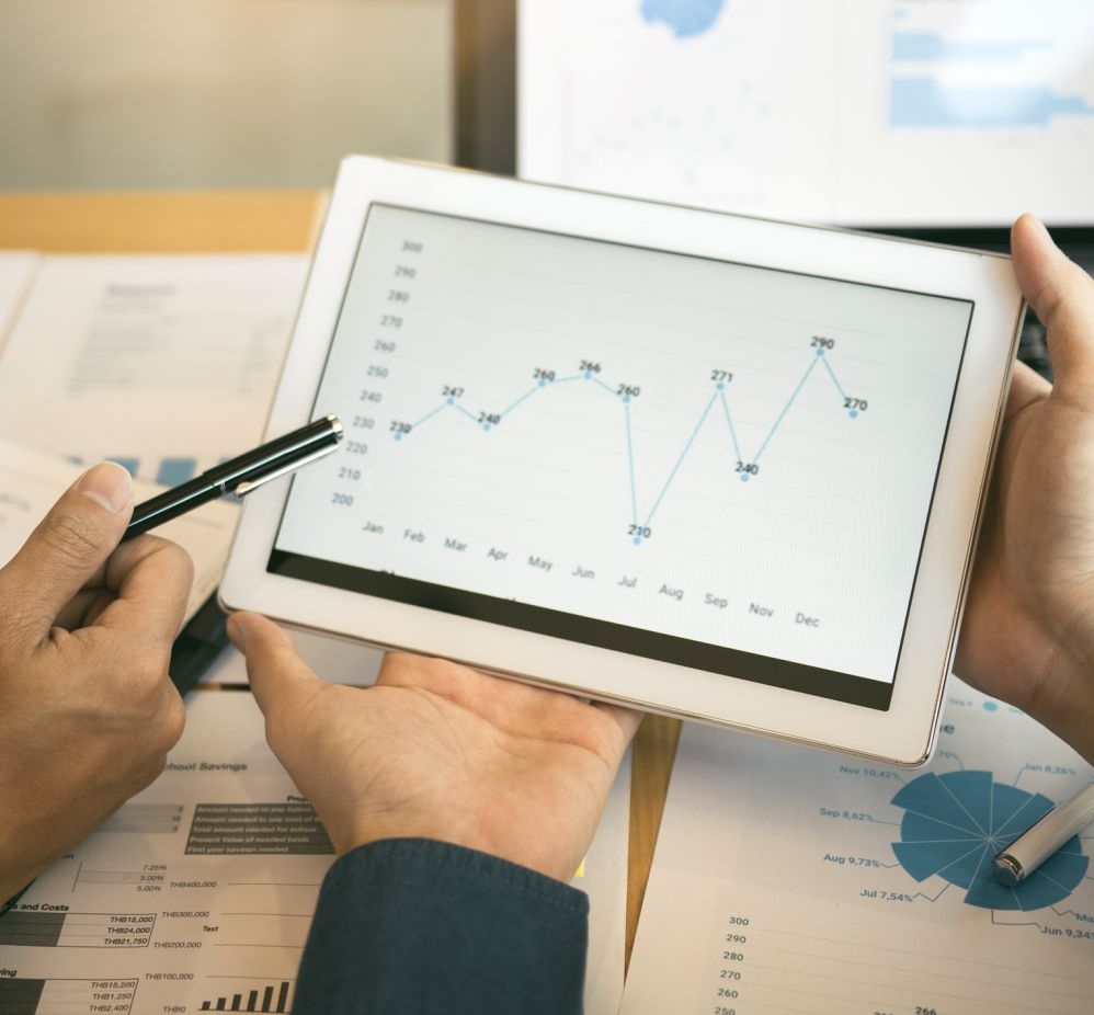 person holding a tablet that displays a chart