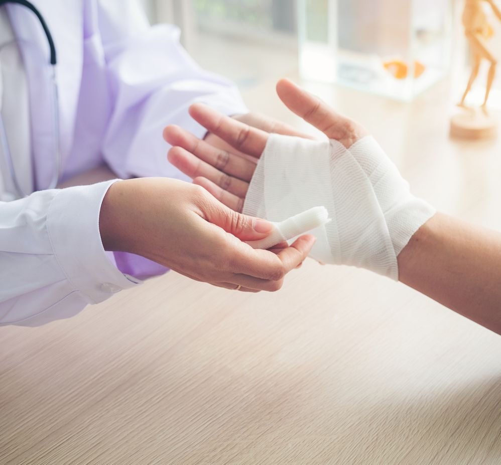 doctor wrapping persons had with gauze