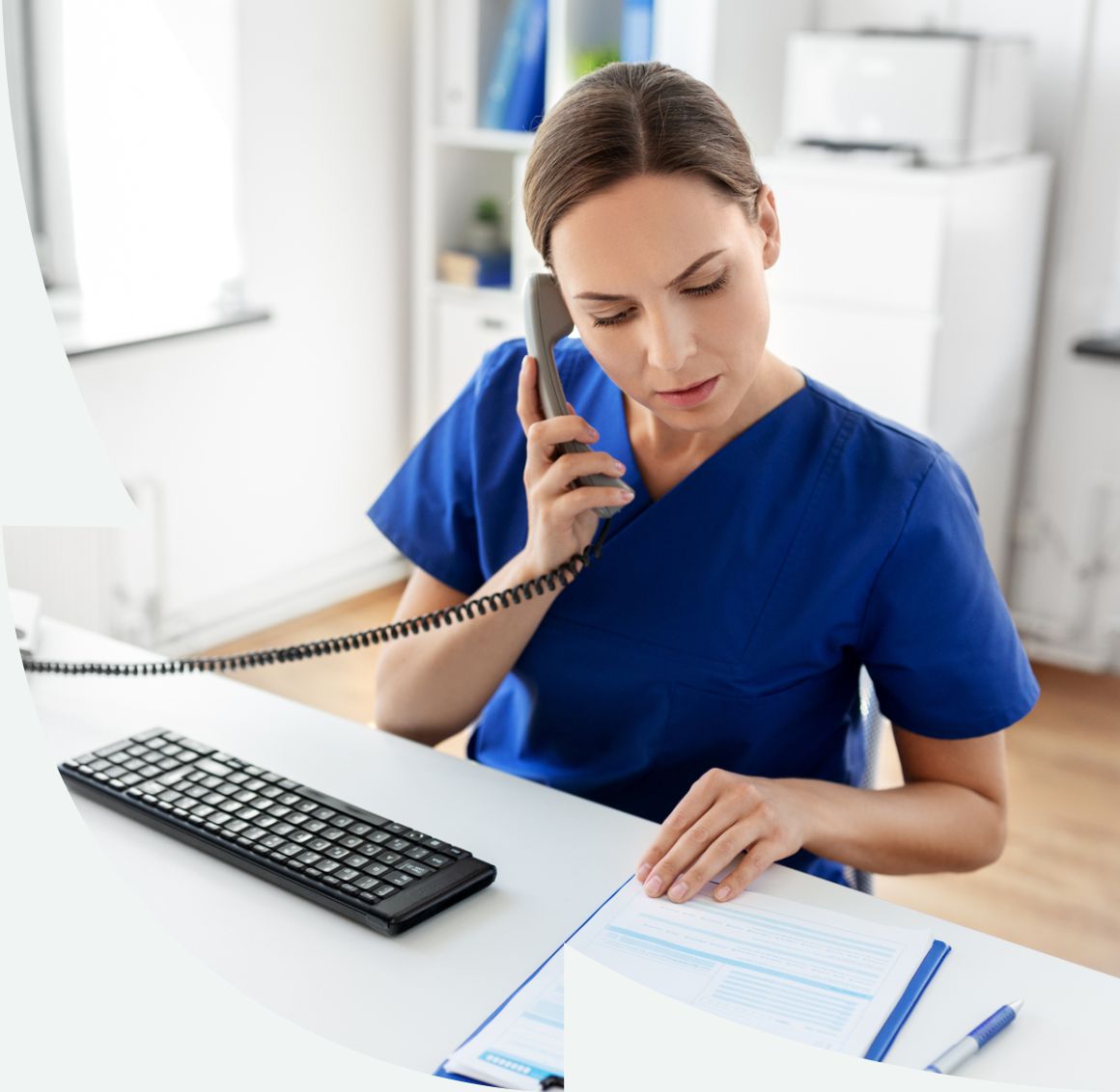 nurse sitting at desk on the phone